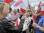 Poseł PiS, Iwona Arent rozdaje flagi zebranym sympatykom partii